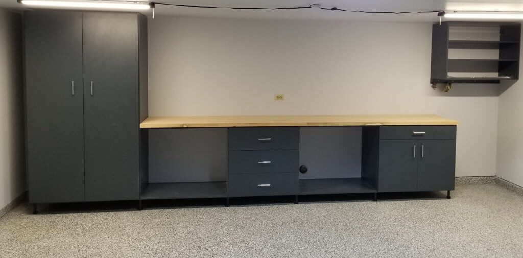 Newly remodeled workbench and dark grayish-blue cabinets installed against the back wall of the makerspace shop