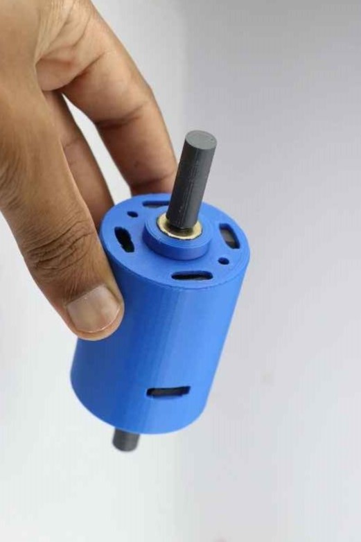 A blue PLA printed hub motor is shown held against a white background.